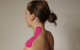Frau mit einem pinken Tape-Streifen von Hals bis Schulter