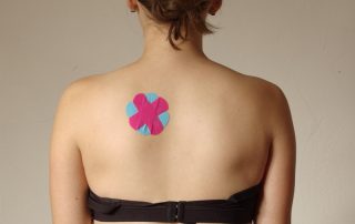 Frau mit kreuzförmigem Tape auf dem Rücken