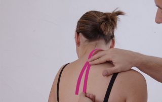 Einer Frau wird ein Tape im Rückenbereich angelegt