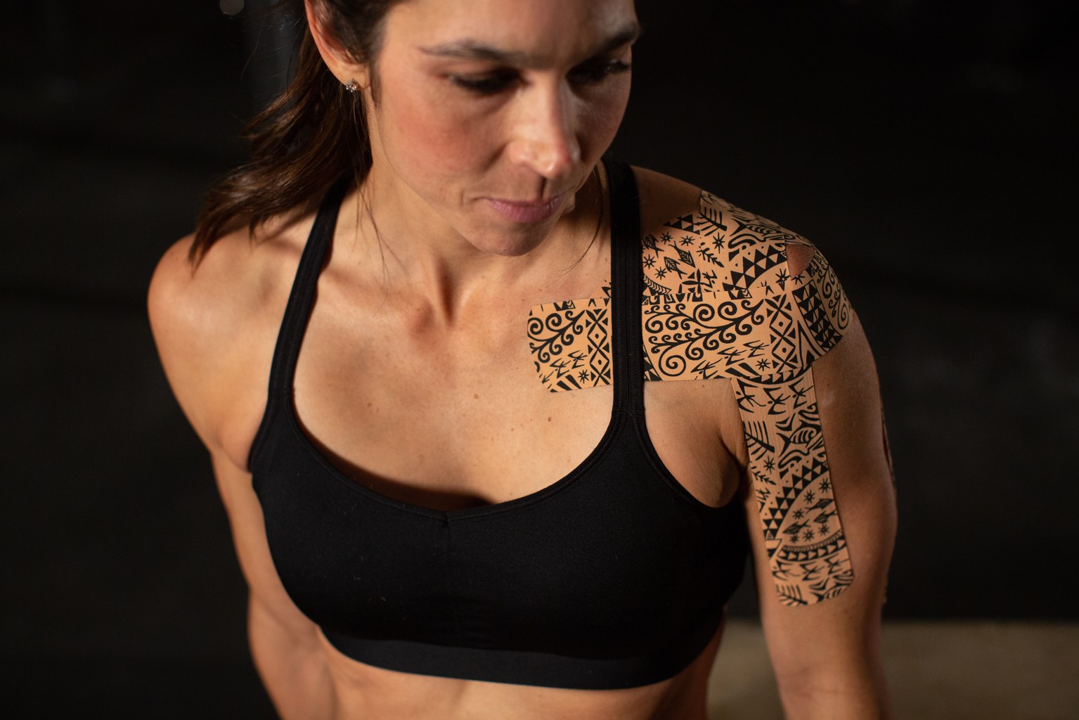 Sportlerin mit Dynamic-Tape-Anlage an Schulter und Oberarm