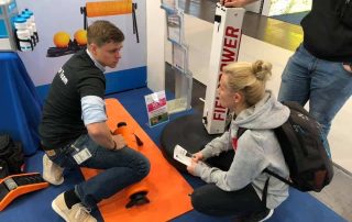 Junger K-Active Mitarbeiter demonstriert Übung mit dem Highroller auf der therapie Leipzig