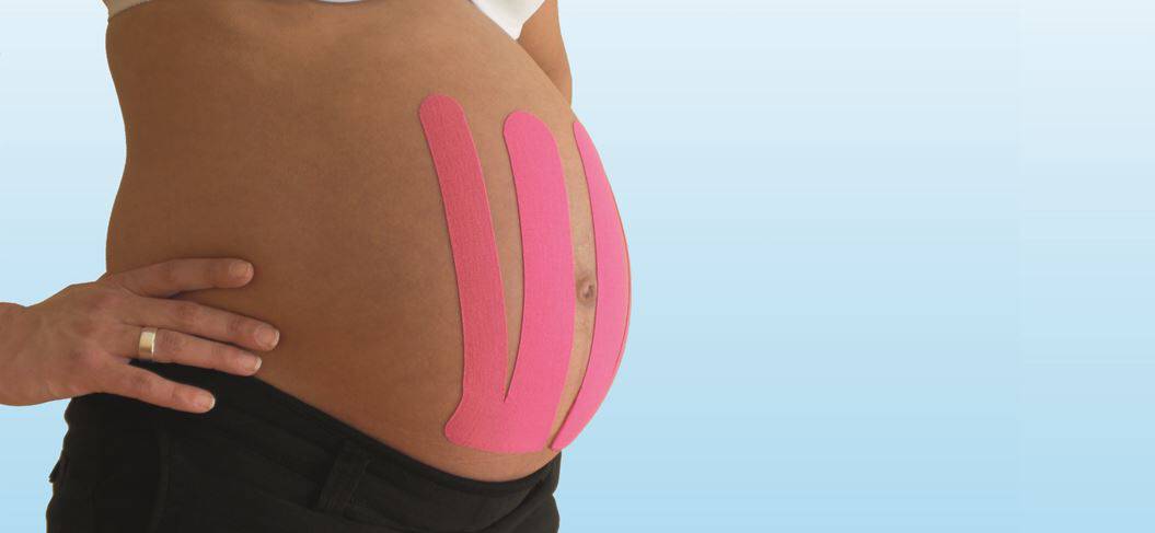 Schwangere mit Tape an der Vorderseite des Bauchs