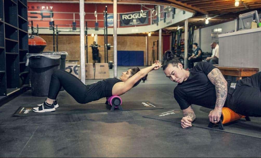 Zwei Menschen massieren sich mit HighRoller im Fitness-Studio