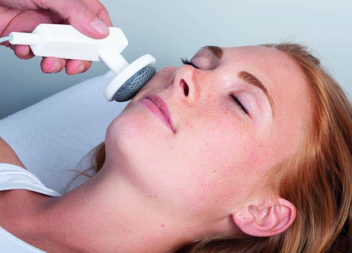 Frau wird mit DEEP OSCILLATION im Gesicht behandelt